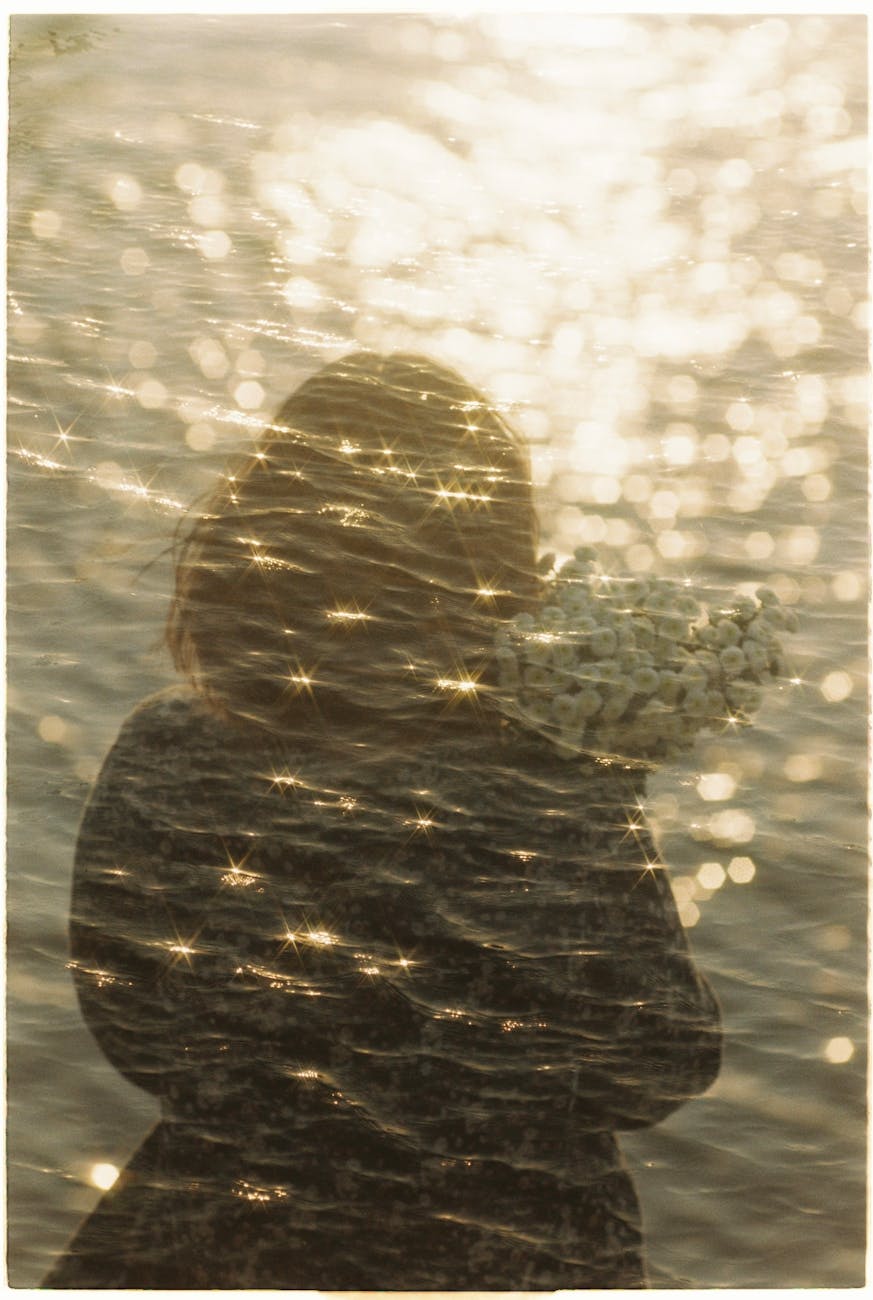 A multi-layered photo showing a person with the reflection of water and light, representing the emotional layers that might be explored in creative expression in art therapy.